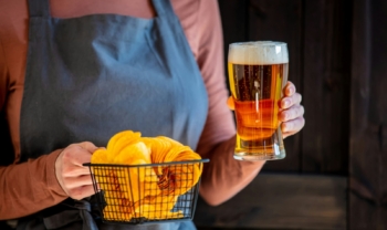 woman waiter holds beer and chips